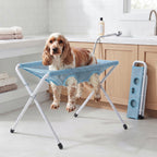 Cocker spaniel standing on the Fetch & Fuzz Shower Stand in a bathroom, folded stand beside it